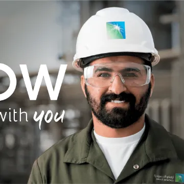 Aramco campaign visual: a worker in a hard hat beside the words “how starts with you”