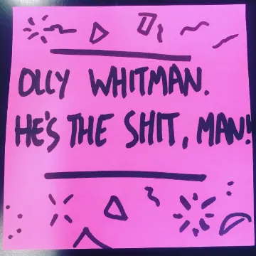 A hand-lettered pink card reading “Olly Whitman. He’s the shit, man!”