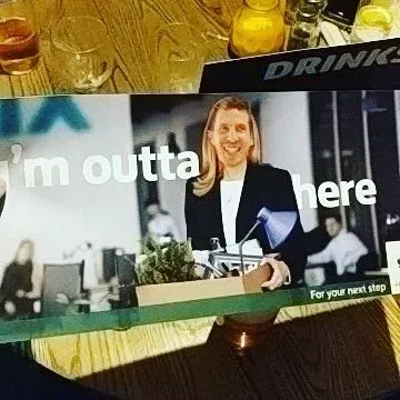 A screen in a bar showing a woman presenting, with the words “I’m outta here”