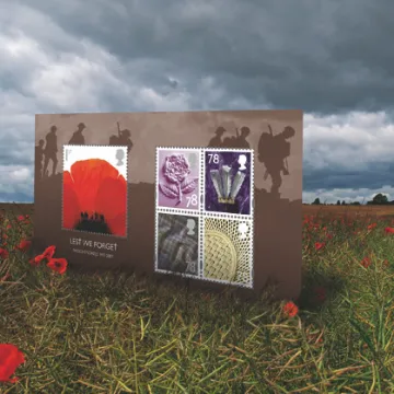 A sheet of remembrance stamps standing in a poppy field under storm clouds